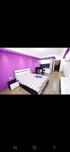 a room with two beds and a purple wall at Tiglina in Galaţi