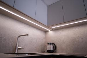 a kitchen with a sink and white cabinets at Chata Rosa in Námestovo +36 photos