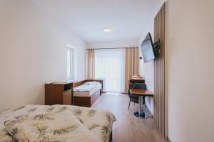 a hotel room with a bed and a desk and a bedroom at Penzion U Libuše Luleč in Lultsch +56 photos