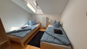 a attic room with two beds and a window at Horská chata Libín in Prachatice