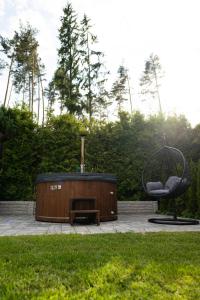 a hot tub and a chair in a garden at Chata Rosa in Námestovo