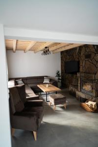 a living room with a couch and a stone fireplace at Chata Rosa in Námestovo