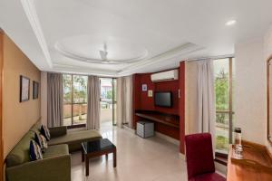a living room with a couch and a tv at The Classic Hotel in Imphal