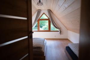 an attic room with a window and a couch at Chata Rosa in Námestovo