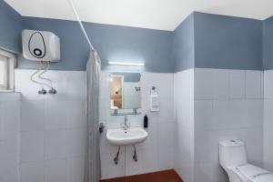 a white bathroom with a sink and a mirror at Hotel Imphal by the Classic in Imphal +11 photos