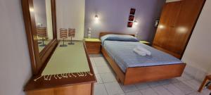 a bedroom with a bed and a large mirror at 5 Suites Αγιόκαμπος Αγιάς in Agiokampos