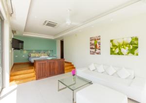 a living room with a white couch and a table at Baan Asan in Taling Ngam Beach