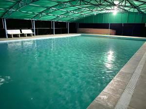 a large pool of blue water in a building at Amrutiya Farm in Bhuj +31 photos