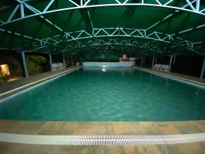 a large pool of blue water with a roof at Amrutiya Farm in Bhuj