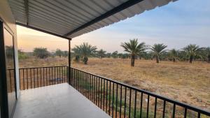 a balcony with a view of a field with palm trees at Amrutiya Farm in Bhuj