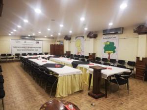 a conference room with tables and chairs and a screen at Hotel Grand Peshawar in Peshawar