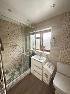 a bathroom with a shower and a sink and a toilet at 16 Bentley Road - Uttoxeter, Comfortable accommodations, SHARED SHOWER ROOM, NO BREAKFAST in Uttoxeter