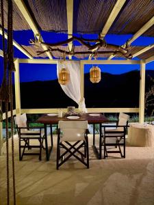 a dining area with a table and chairs and lights at Katerina's House in Volímai +42 photos