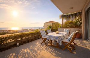 a table and chairs on a balcony with a view of the ocean at Alkion Villa Sea View, Olive Tree Garden & Spacious Terrace in Rhodes Town