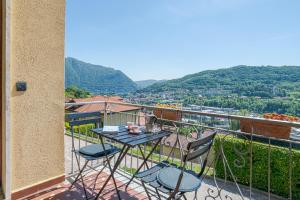 a table and chairs on a balcony with a view at ComoVà in Maslianico