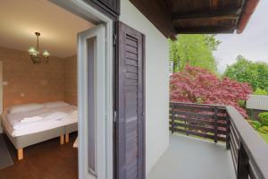 a room with a balcony with a bed and a window at Cosy Vintage House Bled in Bled