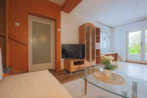 a living room with a flat screen tv and a table at Cosy Vintage House Bled in Bled
