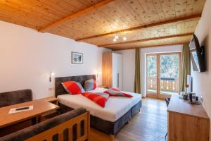 ein Schlafzimmer mit einem Bett, einem Schreibtisch und einem Tisch in der Unterkunft Hotel Chavalatsch in Taufers im Münstertal