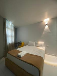 a bedroom with a bed with a light on the wall at Collection O Malacca Formerly Lavender Inn in Malacca
