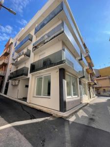a large white building with a lot of windows at Xenia Room in Gela