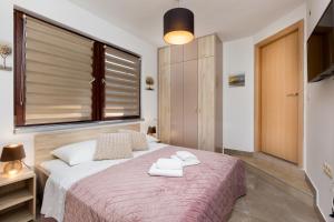 a bedroom with a bed with two towels on it at City center studio apartment in Malinska