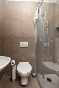 a bathroom with a toilet and a shower and a sink at City center studio apartment in Malinska +25 photos