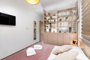 a bedroom with a large bed and a tv at City center studio apartment in Malinska
