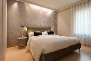 a bedroom with a large bed and a window at Ambiente 90 in Levico Terme