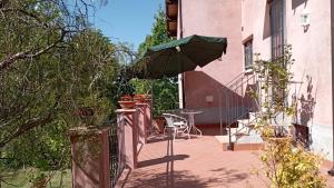 a balcony with a table and an umbrella at Casa Nupa in Torri in Sabina