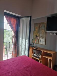 a bedroom with a pink bed and a window at Casa Nupa in Torri in Sabina