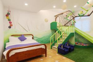 una camera da letto con un letto e una scala verde di Zi Jìng Fang Inn a Città Vecchia di Hengchun