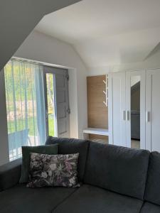 a living room with a couch and a large window at Völgyzugoly Apartman in Kőszeg