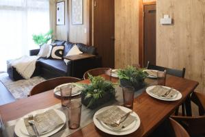 a dining room with a table and a couch at KiyosuBase2 in Kiyosu
