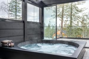 a large bath tub in a room with windows at ConstaVilla by Hilla Villas in Kolari +70 photos