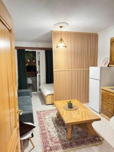 a living room with a coffee table and a kitchen at Studio Astir in Tirana