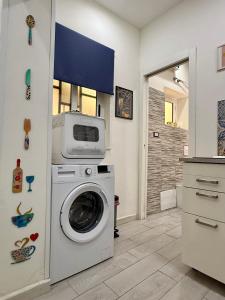 a laundry room with a washing machine in a room at Ballaro's Vibe Historical Apartment Cathedral District in Palermo