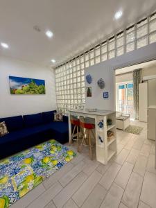 a living room with a blue couch and a table at Ballaro's Vibe Historical Apartment Cathedral District in Palermo