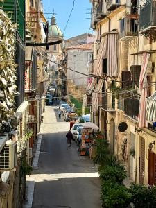an alley with buildings and a person walking down a street at Ballaro's Vibe Historical Apartment Cathedral District in Palermo