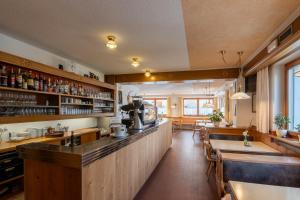ein Restaurant mit Bar und einigen Tischen und Stühlen in der Unterkunft Hotel Chavalatsch in Taufers im Münstertal + 36 Fotos