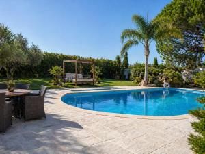 a swimming pool in a yard with a table at Résidence Bozzi in Grosseto-Prugna