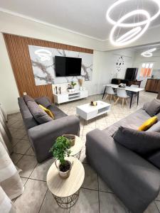 a living room with couches and a flat screen tv at Windmill view apartment in Antimácheia