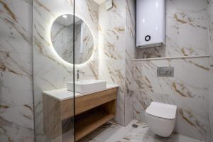 a bathroom with a toilet and a sink and a mirror at SoleMare One-Bedroom Apartment in Burgas +2 photos
