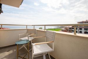 a balcony with two chairs and a table at SoleMare One-Bedroom Apartment in Burgas