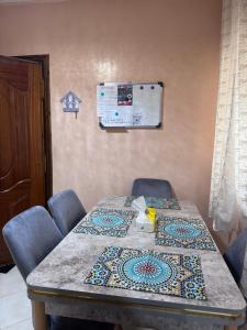 a table in a hospital room with chairs and a chart at Home louah in Fez