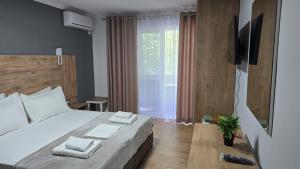 a bedroom with a bed with two towels on it at AA Tirana Center View in Tirana