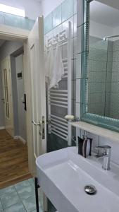 a bathroom with a white sink and a mirror at AA Tirana Center View in Tirana +18 photos