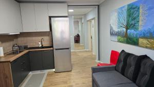 a kitchen with a refrigerator and a couch in a room at AA Tirana Center View in Tirana
