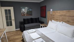 a bedroom with a white bed and a couch at AA Tirana Center View in Tirana