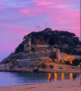 a castle sitting on top of an island in the water at Pensión Jordi Tossa de Mar in Tossa de Mar