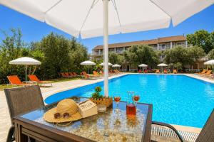 a table with food and drinks next to a swimming pool at Kosmas Apartments in Roda